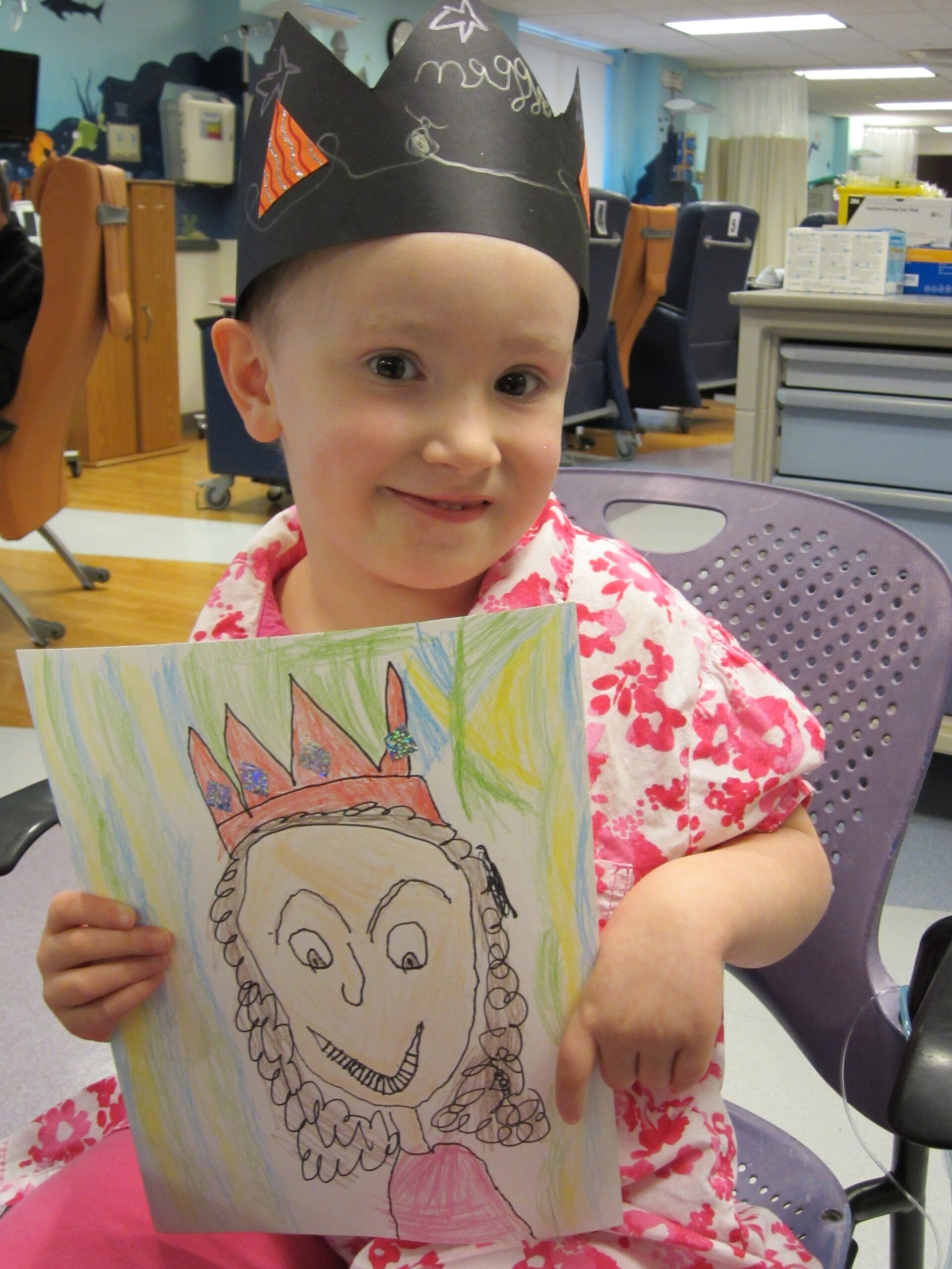 Small girl in homemade crown holding artwork